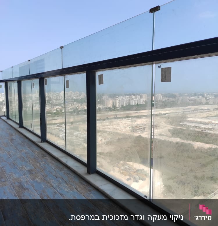 מעקה זכוכית מלוכלך במרפסת עם סימני לכלוך